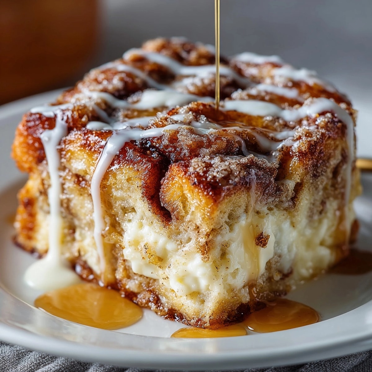 Cinnamon Roll French Toast Casserole served warm with creamy icing drizzle and fresh berries.