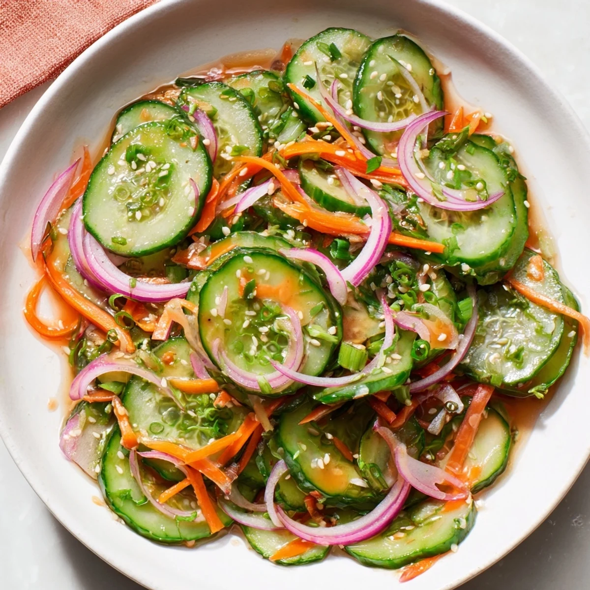 Cucumber Salad Remix garnished with toasted sesame seeds for a vibrant, refreshing bite.  