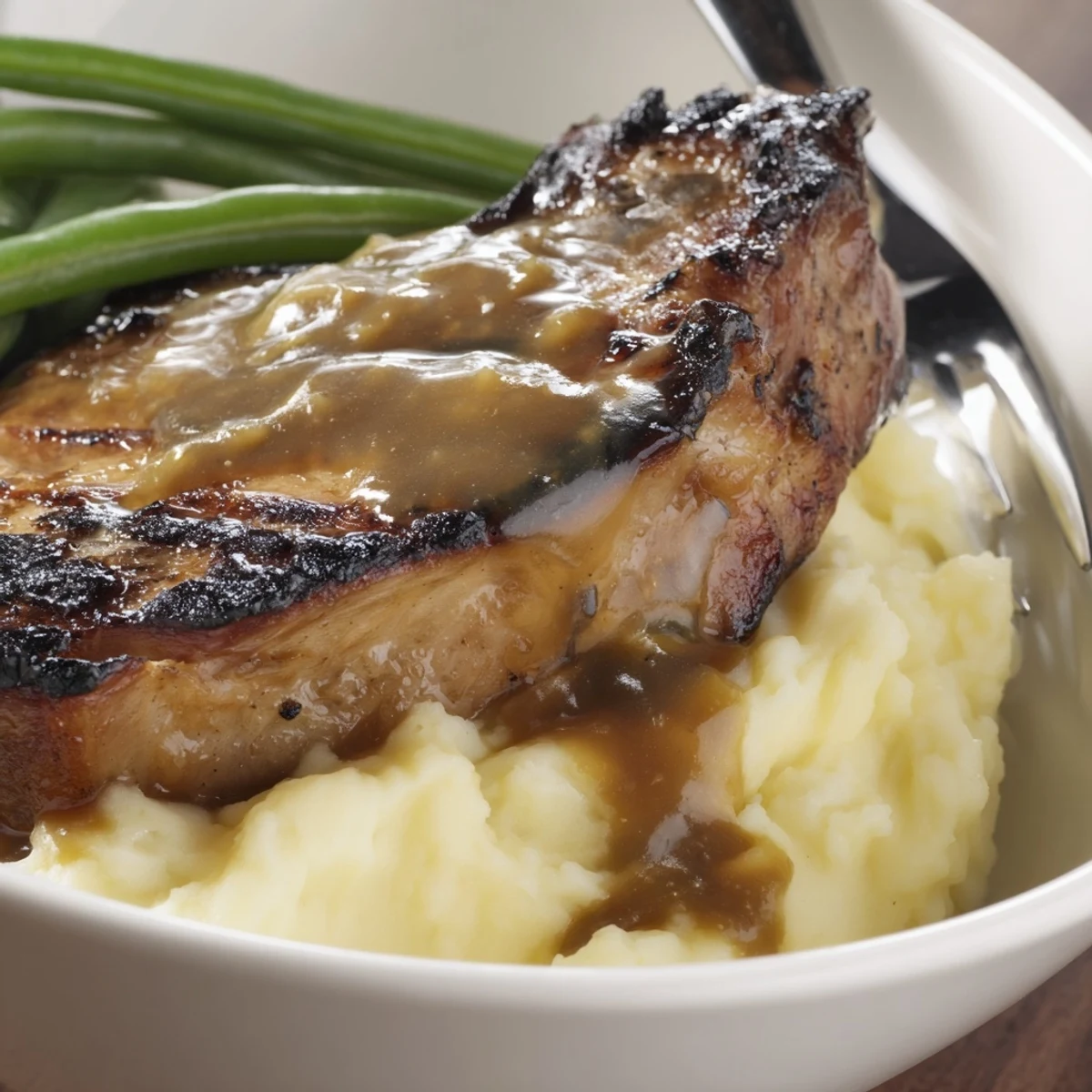 Delicious pork chops & cheddar mash bowl served with vibrant, sautéed green beans.  