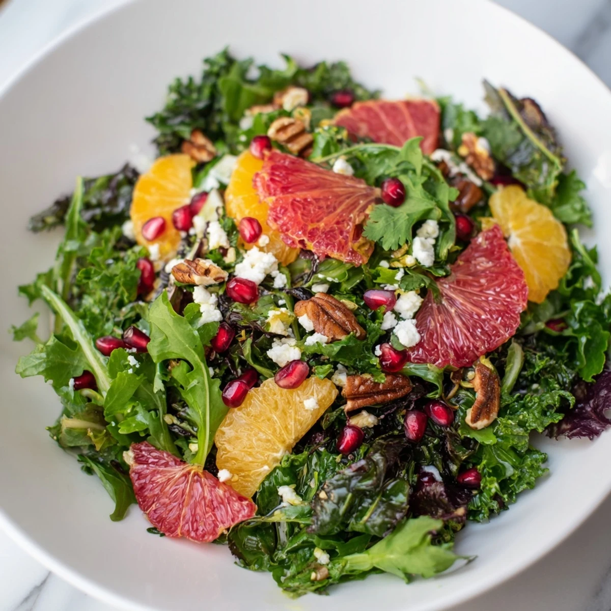 Vibrant Winter Greens Salad, showcasing citrus and pomegranate seeds amidst toasted nuts, ready to enjoy.