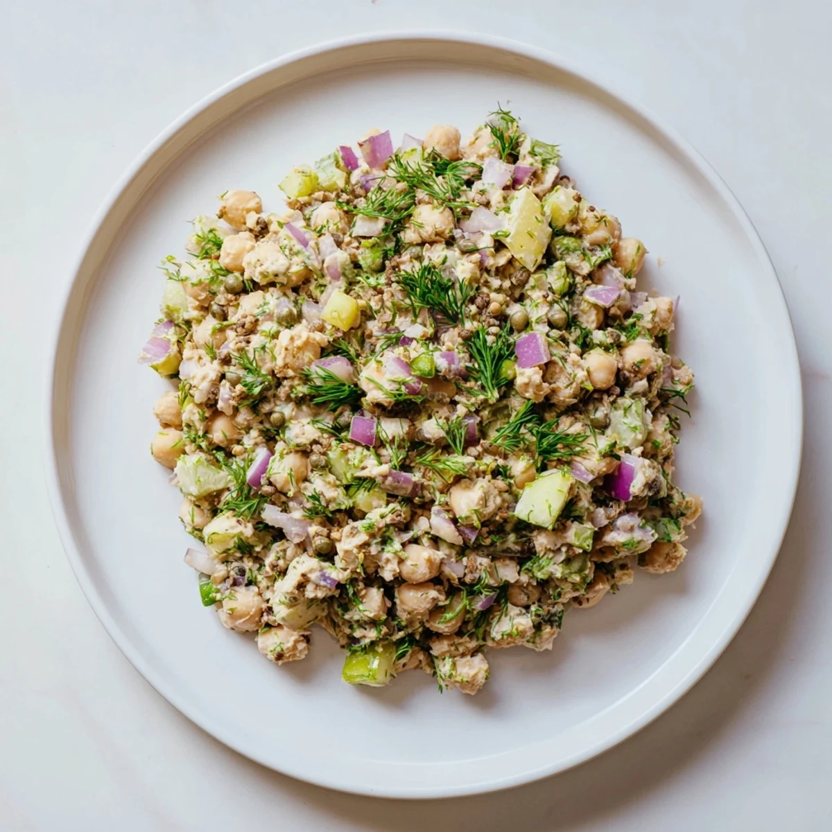 Creamy vegan chickpea tuna salad served on a whole-wheat sandwich, perfect for a satisfying lunch.