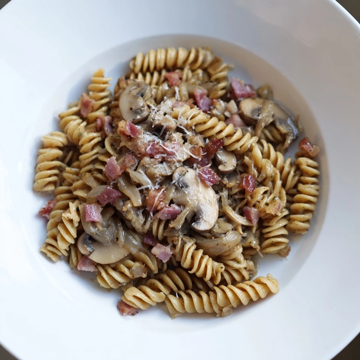 Perfectly cooked fusilli with crispy bacon, sautéed mushrooms, and parmesan cheese for dinner.