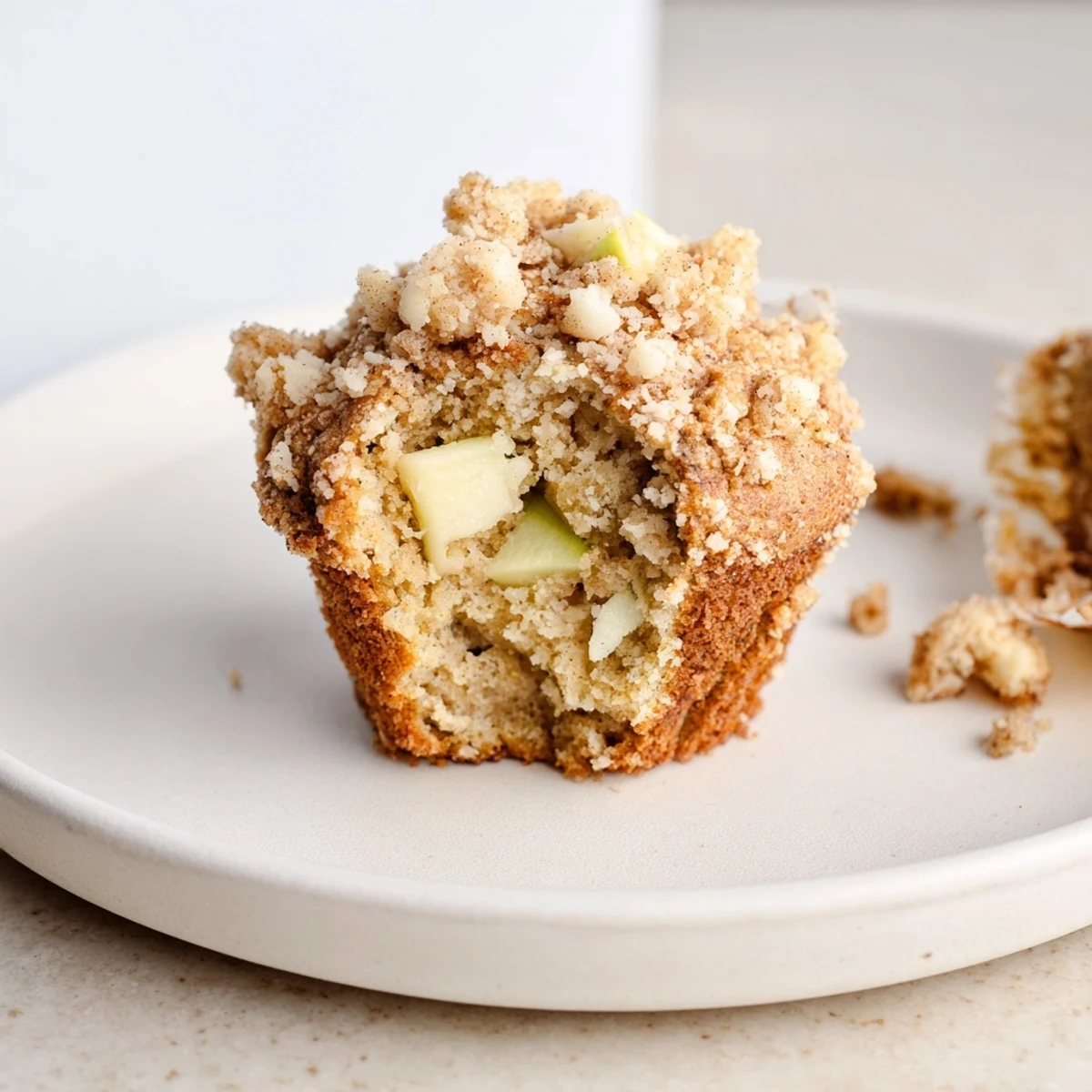Close-up of fluffy tasty apple muffins, featuring a generous crumb topping made with cinnamon and brown sugar.
