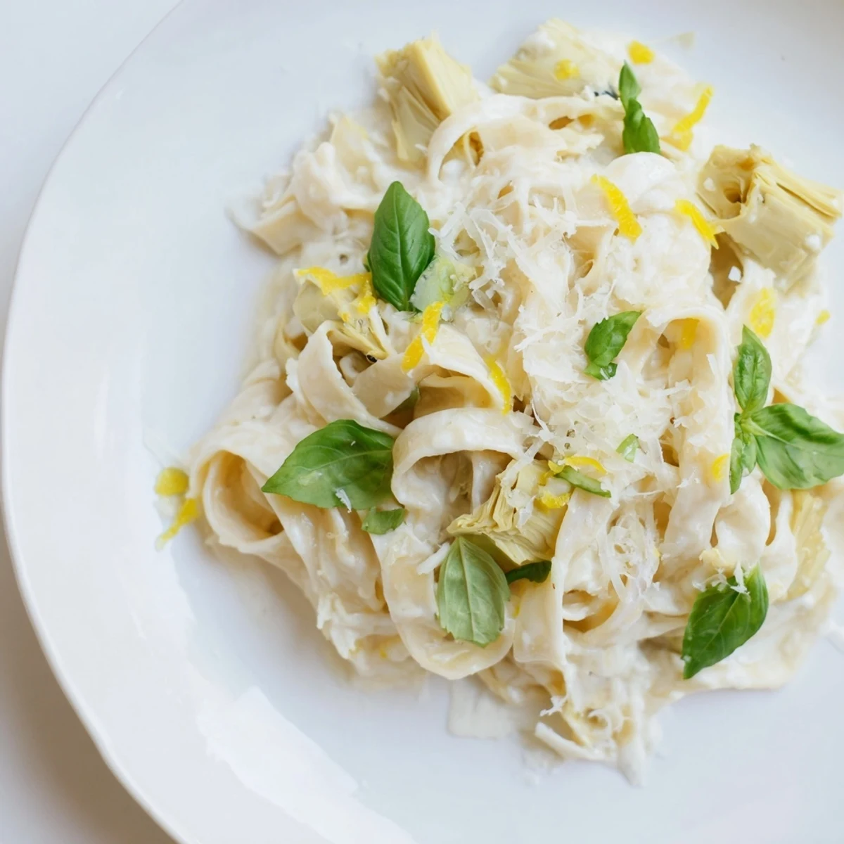 This photo presents a close-up of delicious creamy lemon artichoke pasta, ready for a delightful vegetarian meal.