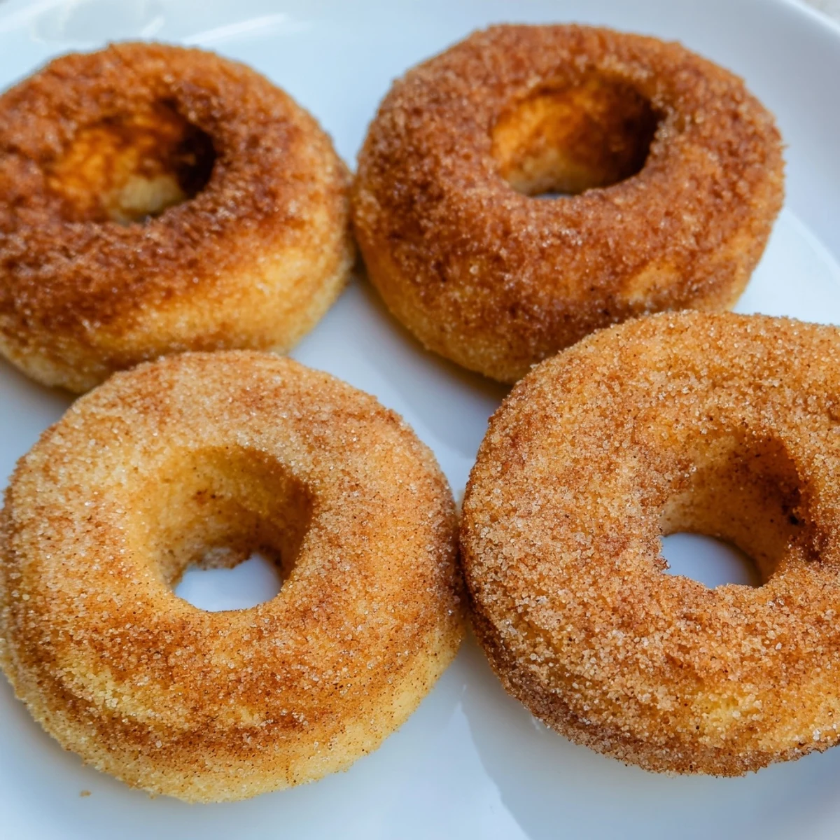 Fluffy 1-Minute Air Fryer Donuts, golden and dusted with cinnamon sugar, served warm for dessert.