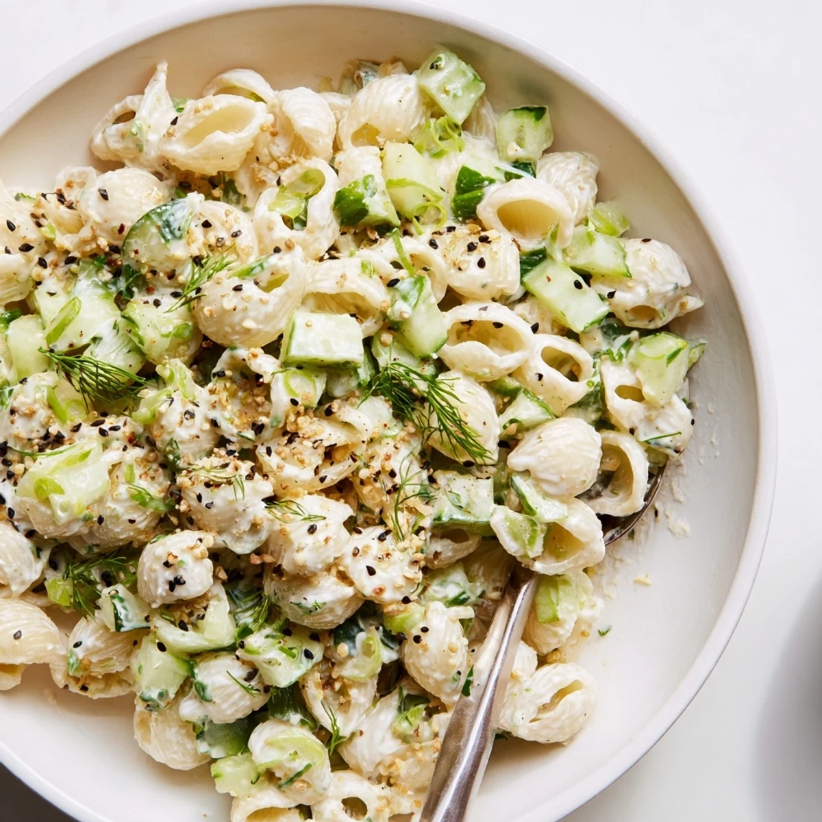 Creamy Cucumber Crunch Pasta Salad features shell pasta, crisp diced cucumbers, fresh dill, and a savory everything bagel seasoning topping.