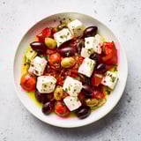 Mediterranean black olive and sun-dried tomato platter, savory feta and roasted red peppers ready.