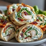 Delightful turkey and cheese tortilla pinwheels layered with fresh spinach, rolled and sliced for easy, crowd-pleasing appetizers or lunch ideas.  