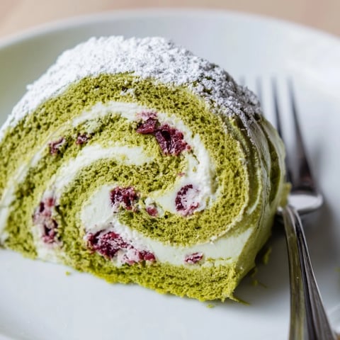 Light and airy matcha Swiss roll filled with tangy cranberry cream, perfect for dessert.  