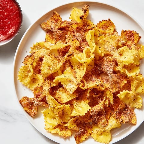 Crispy pasta chips seasoned with garlic and smoked paprika for delicious snacking.  