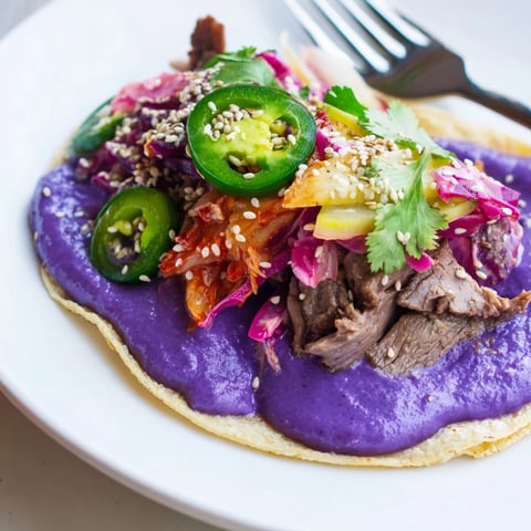 Colorful Global Street-Food Fusion Tacos with ube crema and fresh toppings ready to serve.  