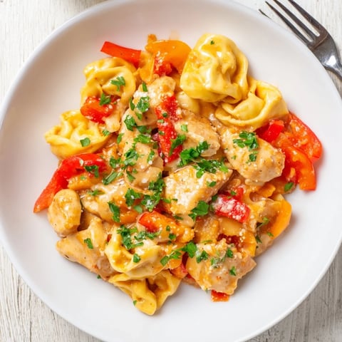 Vibrant Zesty Cajun Garlic Parmesan Chicken Tortellini garnished with fresh parsley and cheese.  