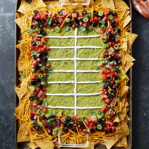 A fully loaded Football Field Nacho Platter with melted cheese, brimming with savory toppings.