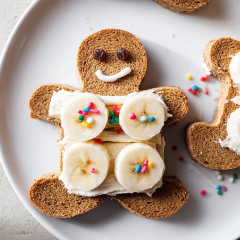 Gingerbread man sandwich cutouts with bright apple eyes and banana smiles, a fun kids lunch!