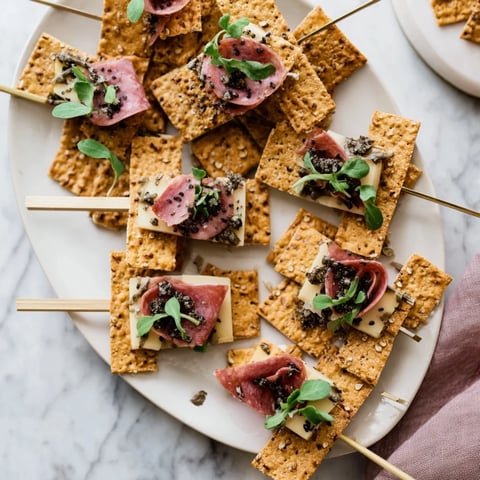 Layered Urban Skyline appetizer shows vertically stacked crackers, cheese, and meats for creative snacking.