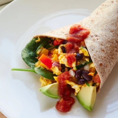 Scrumptious veggie-loaded breakfast burrito: a warm, overflowing wrap with colorful veggies, eggs, and cheese.