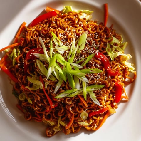 Steaming spicy ramen stir fry, a colorful mix of noodles and veggies, ready to enjoy.
