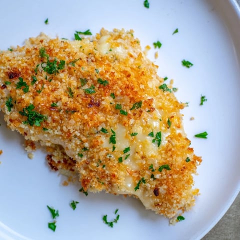 Golden, bubbly cheesy baked chicken breast, a simple American dinner, ready to eat.