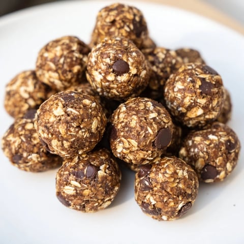 Golden banana chocolate chip energy balls on a wooden board, showcasing the chewy texture and natural sweetness from ripe bananas.