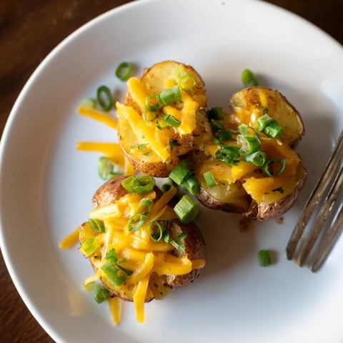 Crispy smashed green onion potato bombs topped with melted cheese and herbs.  