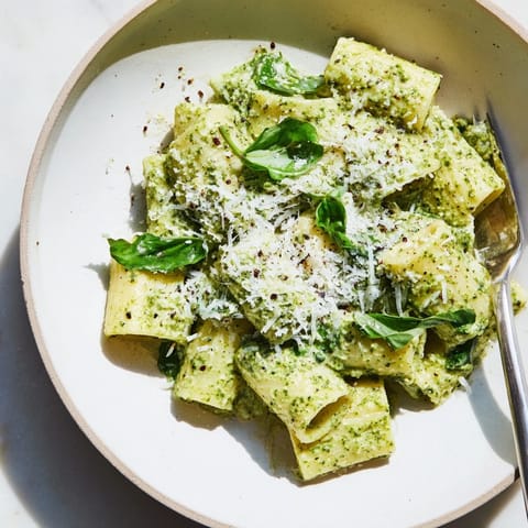 Homemade Ricotta Spinach Pesto Pasta is tossed in creamy sauce, garnished with basil.