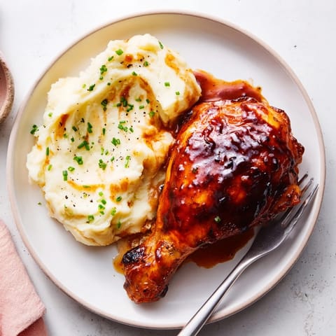 Oven-baked honey BBQ chicken thighs glazed to perfection, served with garlic mashed potatoes.  