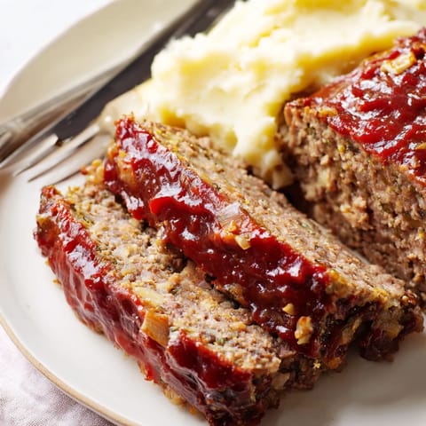 A comforting classic meatloaf served hot with rich, buttery mashed potatoes.  