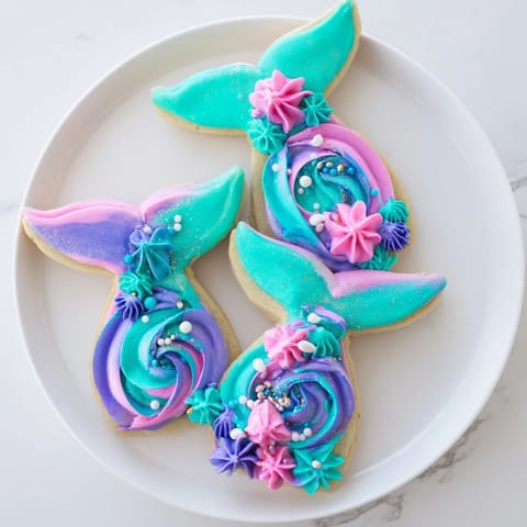 Vibrant teal, pink, and purple buttercream create colorful Mermaid Tail Under the Sea Sweets, a dreamy dessert.