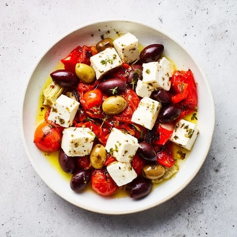 Mediterranean black olive and sun-dried tomato platter, savory feta and roasted red peppers ready.