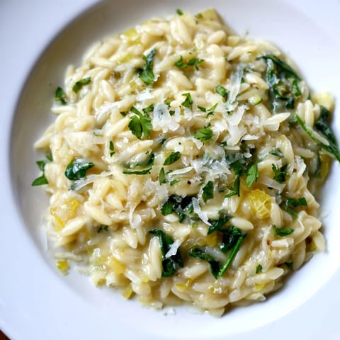 Close-up of a bubbling skillet making delicious one-pot creamy orzo, ready to serve with a spoon.