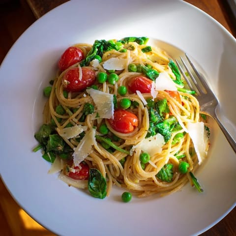 Spring Veggie One-Pot Spaghetti features al dente pasta with garlic, spinach, and red onion, ready for a quick weeknight dinner.