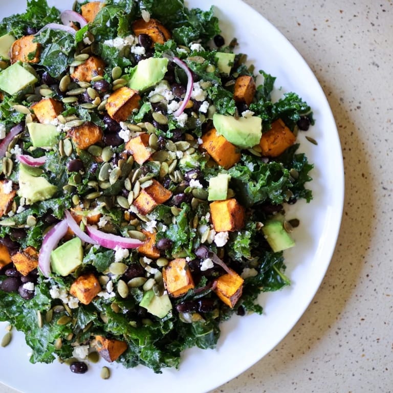 A healthy and delicious Massaged Kale Salad presented with roasted sweet potato and a lime dressing.