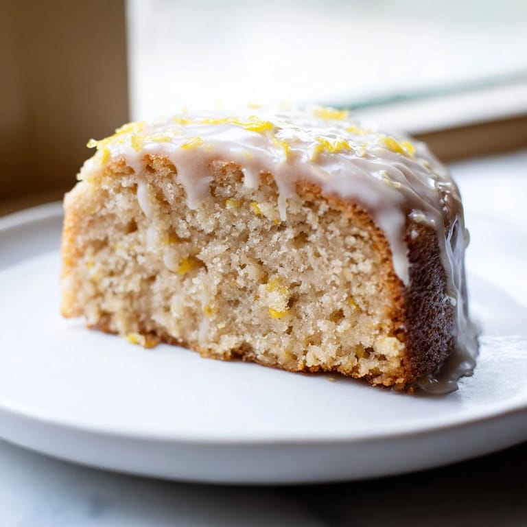 Warm, golden Lemon Yogurt Cake, perfect for breakfast or tea time, served with fresh berries.