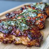 Baked honey garlic chicken thighs with crispy skin and a glossy glaze, served with fresh parsley and sesame seeds.  